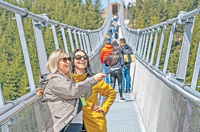 遊客踏上吊橋拍照留念。