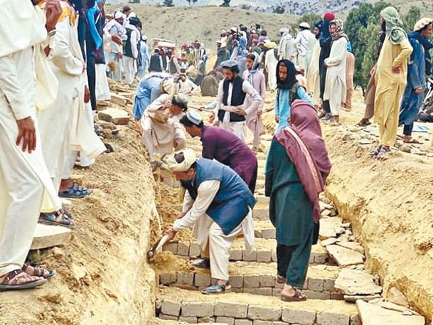 民眾挖長溝用作埋葬地震死者。