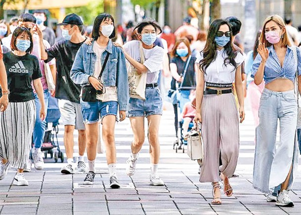 台灣疫情未止，民眾外出仍佩戴口罩。