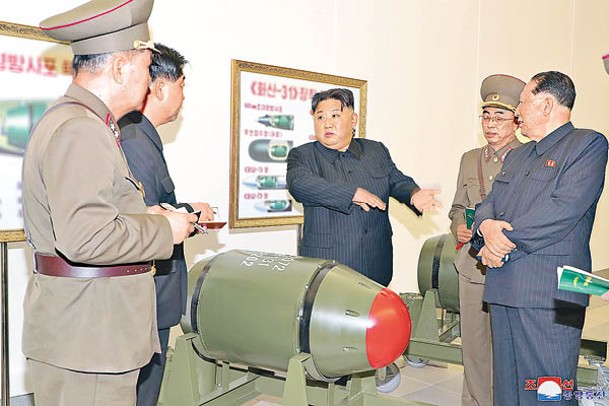 北韓領袖金正恩（中）與官員視察疑似核彈頭。