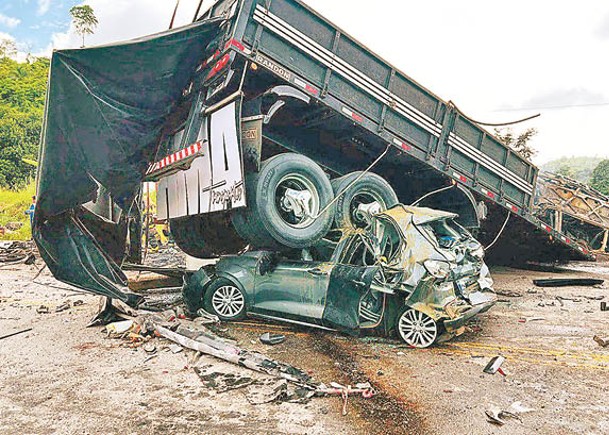 汽車被困在貨車下方。