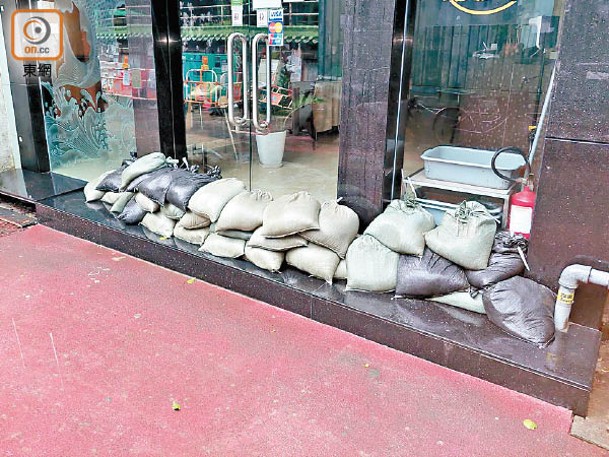 鯉魚門有食肆在門外堆放沙包。（張開裕攝）