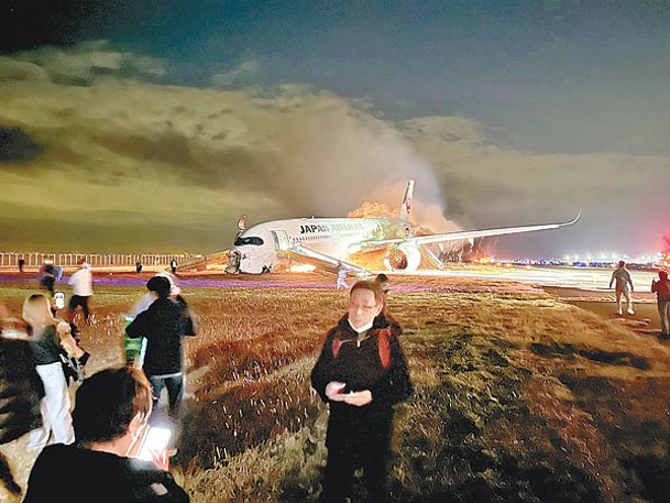 乘客利用逃生滑梯撤離起火的日本航空客機。