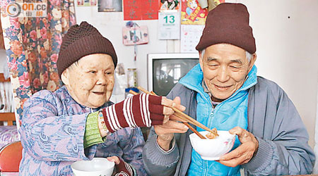 物價飛漲下，明叔（右）與妻子只能過着清茶淡飯的生活，坦言贈米計劃減輕不少經濟負擔。