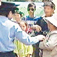 戴帽的北川婦人在接受記者採訪時遭公安帶走。（有線電視畫面）