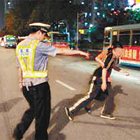 在深圳醉酒駕駛的鄧姓港人（黑衫者）被警員帶走。（兩岸組深圳傳真）