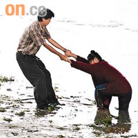 台北縣一名婦人不慎陷入淤泥，旁人幫忙將她拉出。	（本報台北傳真）