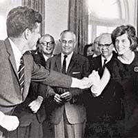美國前總統甘迺迪（左）簽署法案，成立首個總統智障人士委員會後，向尤妮絲贈送用作簽名的筆。	（資料圖片）