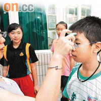 台北一間小學的學生進校時需檢測體溫。	（本報台北傳真）