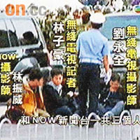 三名本港記者坐在地上，旁邊有警員看守。	（有線電視畫面）