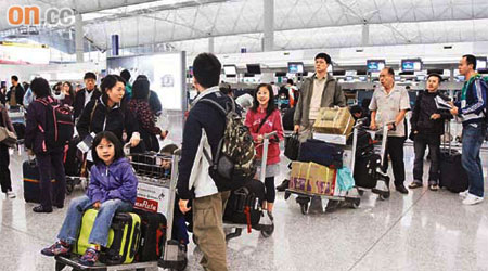 昨日本港仍有市民出發往泰國，在機場辦理登機手續。	（沈厚錚攝）