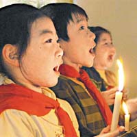 重慶鋼峰小學生在燭光中為逝者祈禱。	（新華社圖片)