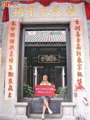 廣州青年阿卓化身「絲襪男」在獵德村的祠堂外舉牌呼籲保護本土文化。（廖怡德攝）