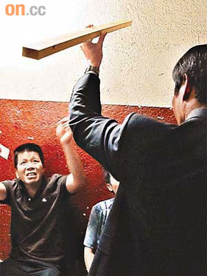 警員拿起劉雪紅自殺用的木條向陳振國（左）查詢。	（本報美國傳真）