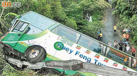 旅遊巴連同損毀的公路護欄墮落山坡。	（本報新竹傳真）