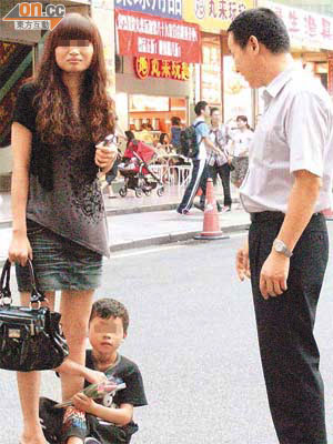 深圳有小童纏着女途人賣花。 （廖怡德攝）