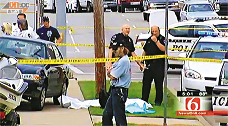警方用白布蓋着其中一名死者的屍體。	（本報美國傳真）