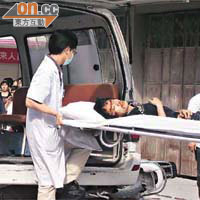 受傷青年被送上救護車。