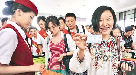 京滬高鐵昨日正式營運，北京旅客興奮展示車票。	（中新社圖片）