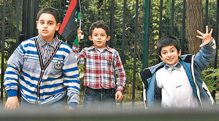 數名利比亞兒童在位於北京的利比亞大使館門外，慶祝卡達菲被擒。（中新社圖片）
