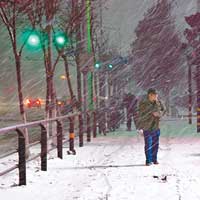 遼寧瀋陽市民夜間冒着大風雪出行。（中新社圖片）