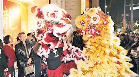 美國比華利山名店街有民眾舞獅慶賀新年。（中新社圖片）