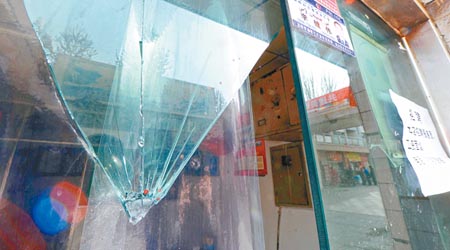 幸福路步行街一間被砸店舖的玻璃仍留有血漬。（中新社圖片）