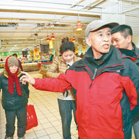 鄭州市民在家樂福肉櫃前，譴責商家欺騙消費者。（中新社圖片）