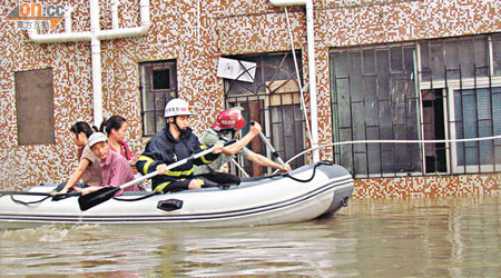 深圳龍崗區一工業區發生內澇，救援人員開衝鋒艇救出被困民眾。（本報深圳傳真）
