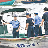 漁政人員巡查停靠在海南瓊海潭門中心漁港的漁船。（中新社圖片）