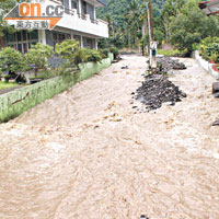 高雄六龜山區街頭有洪水混合泥流直沖而下。（郭良傑攝）