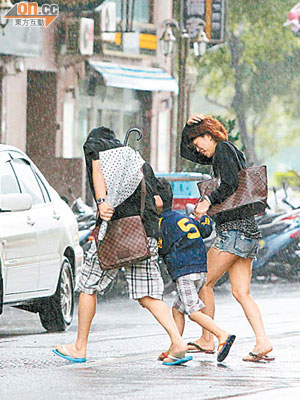 高雄民眾在颱風大雨外出甚為狼狽。（本報高雄傳真）