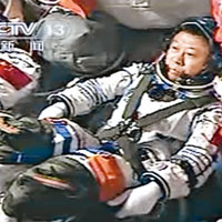 航天員劉旺操控座位兩邊手柄控制神九與天宮進行對接。（中新社圖片）