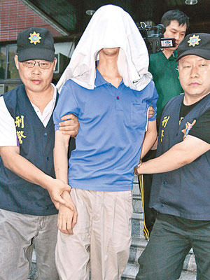 涉案的林姓男子（中）被警方蒙頭帶走。（中央社圖片）