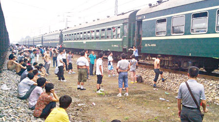 部分乘客在河南等候列車重開時，難忍悶熱下車透氣。（互聯網圖片）