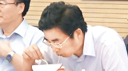 郭金龍在救災會議上吃即食麵，被外界狂轟做騷。（電視畫面）