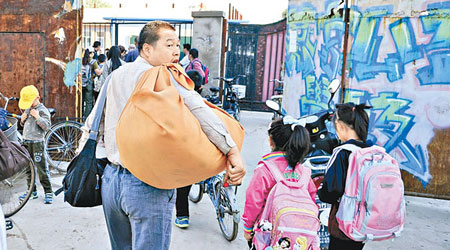 北京有民工家長為子女帶大批用品上學。（中新社圖片）
