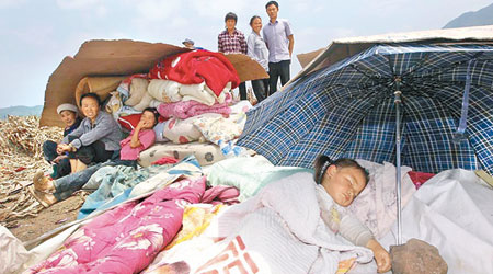 席地而睡<br>彝良縣大寨村災民以雨傘當帳棚。