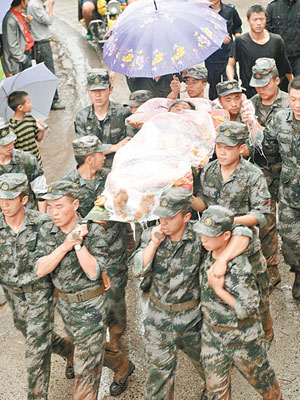 廿多名官兵昨冒雨抬着身受重傷的村民，急行卅公里到達縣區醫院。（中新社圖片）