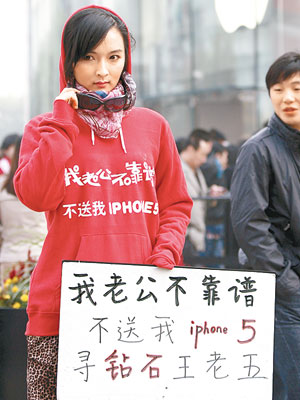 一名女子以紙牌配合字句T恤，指摘丈夫不為自己購買iPhone 5，希望另找鑽石王老五。（中新社圖片）