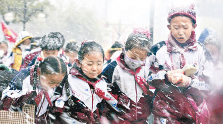 甘肅武威市小學生冒雨雪回家。（中新社圖片）