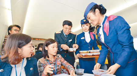 京廣高鐵服務員向試坐的記者奉上食物。(中新社圖片)