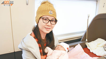 赴港產子的陳姓婦人帶着初生嬰兒搭乘高鐵回京。（黃少君攝）