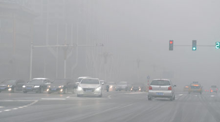 河北遭遇大霧，能見度極低，車輛要開車燈緩慢行駛。（中新社圖片）