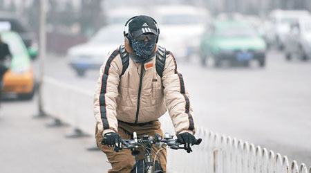 西安有民眾全套防霧霾天氣裝備，戴帽、口罩及墨鏡騎單車出行。（中新社圖片）