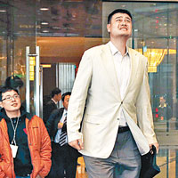 全國政協委員姚明（右）在北京的酒店外抬頭看天，皺起眉頭。（中新社圖片）