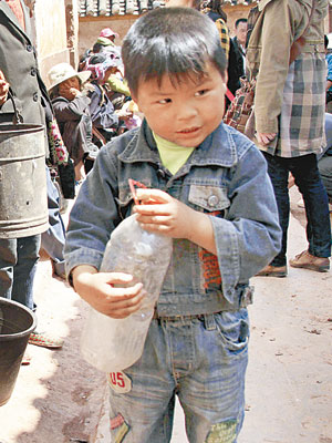 雲南小孩子也要排隊輪候取水。（中新社圖片）