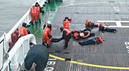 救援人員正進行搜救，打撈出遇難船員。（中新社圖片）