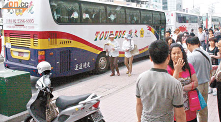 多輛載着大陸客的遊覽車停在一家港資珠寶店門口。（郭良傑攝）