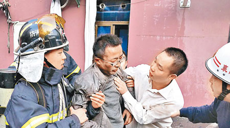 消防員從失火酒店救出被困男子。（中新社圖片）